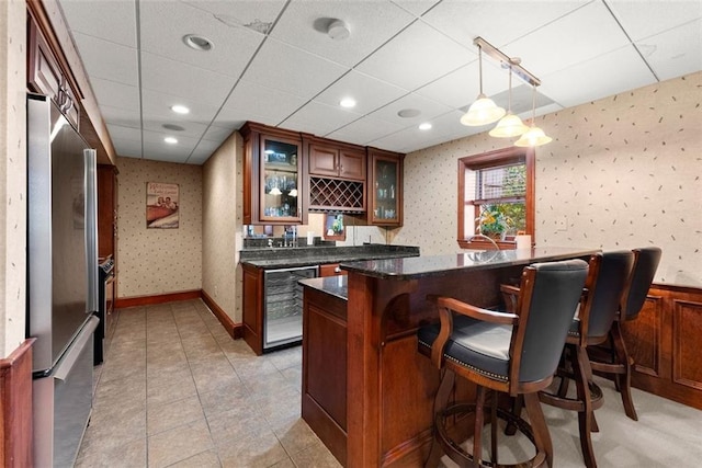 1374 Riverside Dr, Gainesville, GA 30501 - indoor wet bar featuring beverage cooler, stainless steel fridge, wallpapered walls, a paneled ceiling, and hanging light fixtures