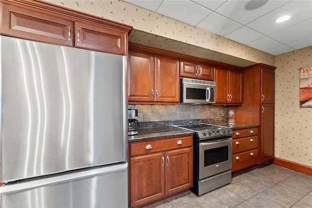 1374 Riverside Dr, Gainesville, GA 30501 - kitchen featuring stainless steel appliances, brown cabinets, wallpapered walls, light tile patterned flooring, and baseboards