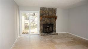 unfurnished living room featuring a stone fireplace