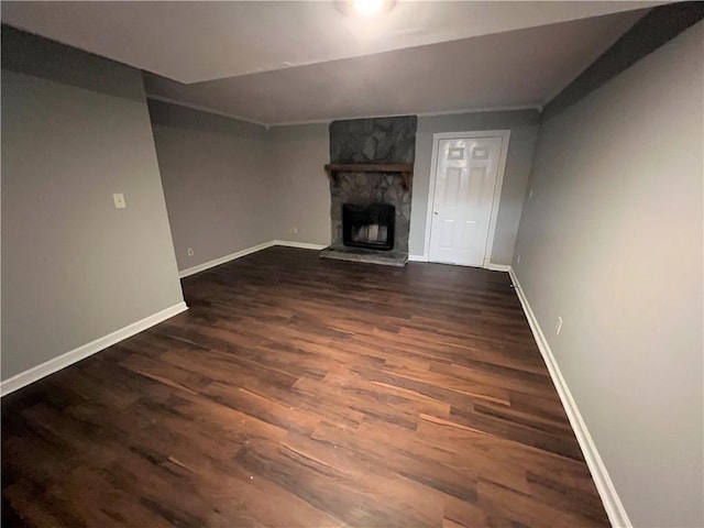 unfurnished living room featuring a fireplace and dark wood-type flooring