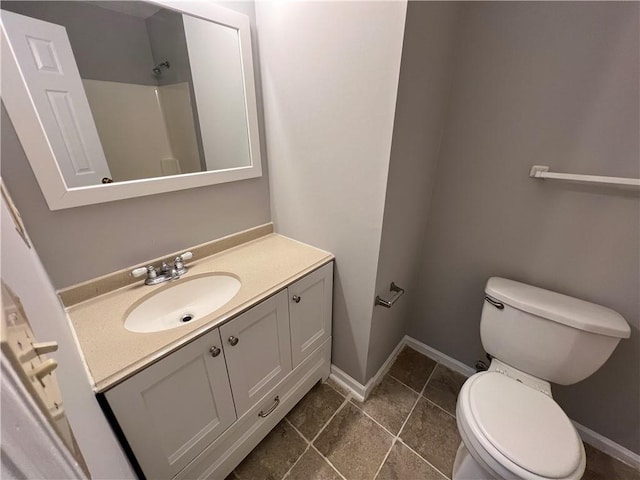 bathroom featuring tile patterned flooring, vanity, toilet, and walk in shower