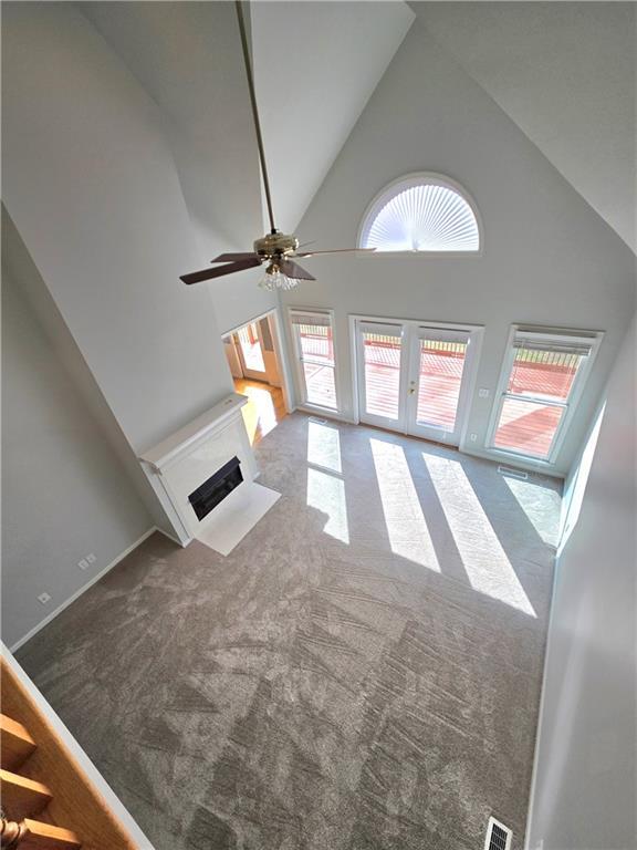 carpeted empty room featuring baseboards, visible vents, and ceiling fan