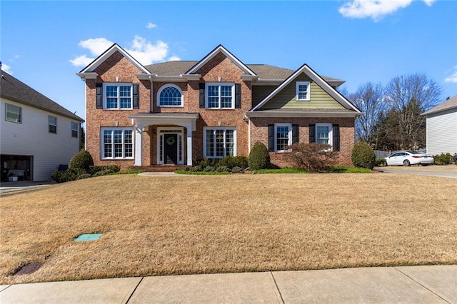 view of front of house featuring brick siding and a front lawn