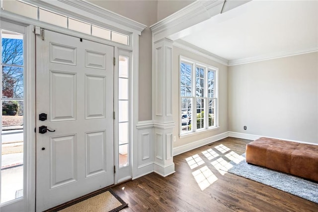 entrance foyer featuring dark wood finished floors, decorative columns, baseboards, and ornamental molding