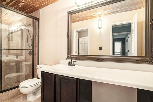 bathroom featuring tile patterned flooring, toilet, brick ceiling, vanity, and a shower with shower door