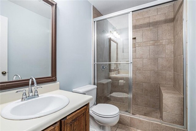 bathroom with vanity, toilet, and a shower with shower door