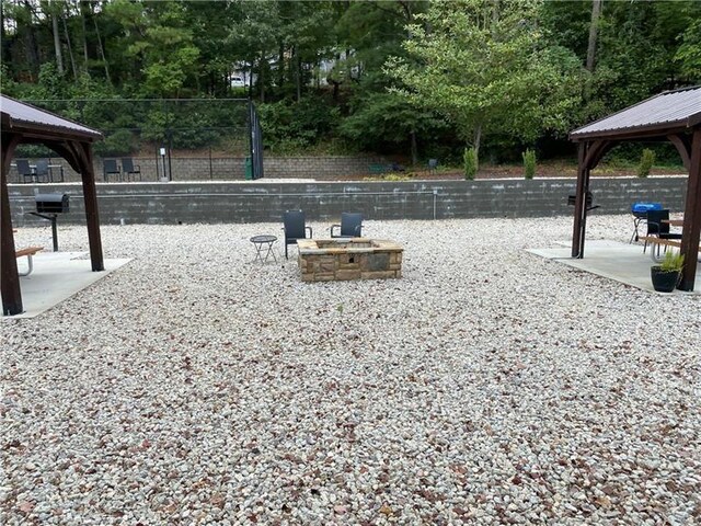 view of property's community with a gazebo and an outdoor fire pit