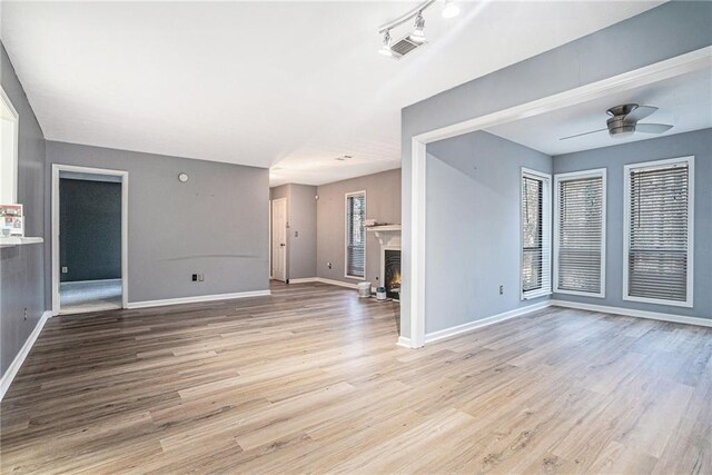 unfurnished living room featuring ceiling fan and light hardwood / wood-style flooring