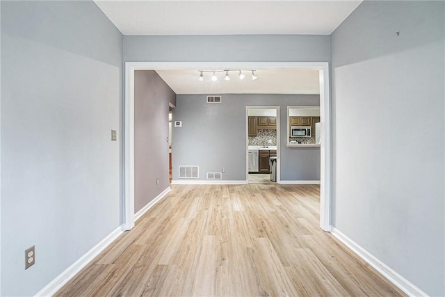 interior space with rail lighting and light hardwood / wood-style flooring