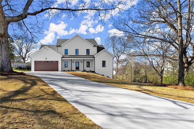 modern inspired farmhouse with an attached garage, a shingled roof, driveway, and a front lawn