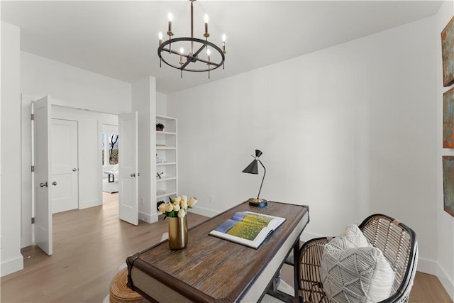 office space featuring light wood-type flooring, baseboards, and a chandelier