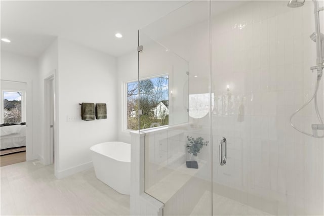 bathroom with recessed lighting, a freestanding tub, a stall shower, and ensuite bathroom