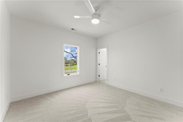 spare room featuring visible vents, a ceiling fan, baseboards, and carpet floors