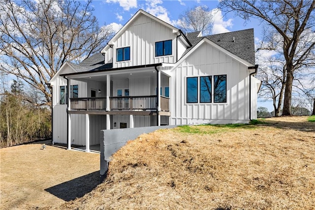 back of property with board and batten siding and roof with shingles