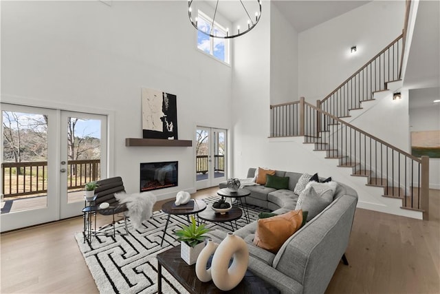 living area with french doors, stairs, and wood finished floors