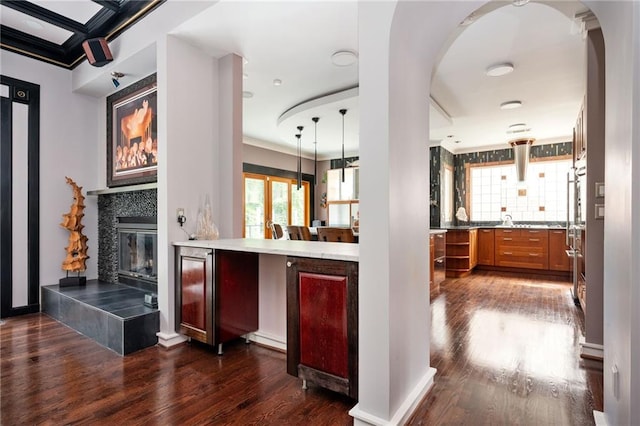 1216 E Rock Springs Rd NE, Atlanta, GA 30306 - bar featuring dark wood-style floors, healthy amount of natural light, arched walkways, ornamental molding, and a tile fireplace