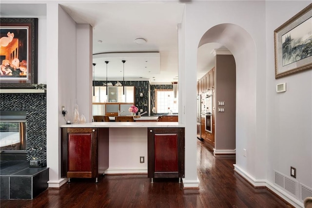 1216 E Rock Springs Rd NE, Atlanta, GA 30306 - kitchen featuring dark wood-style floors, arched walkways, light countertops, and a tiled fireplace