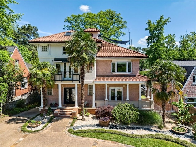 1216 E Rock Springs Rd NE, Atlanta, GA 30306 - mediterranean / spanish house with french doors, a tile roof, a balcony, driveway, and brick siding