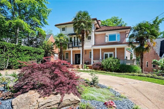 1216 E Rock Springs Rd NE, Atlanta, GA 30306 - mediterranean / spanish-style house featuring a porch, a balcony, french doors, a tiled roof, and brick siding