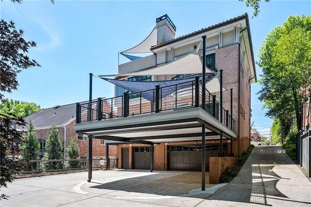 1216 E Rock Springs Rd NE, Atlanta, GA 30306 - back of property with brick siding, a balcony, an attached garage, a chimney, and driveway