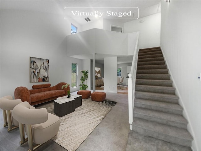 living room with a high ceiling and carpet