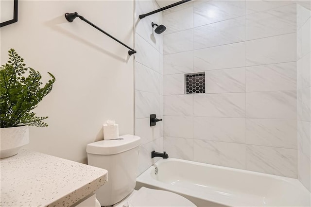 full bathroom with tiled shower / bath, toilet, and vanity