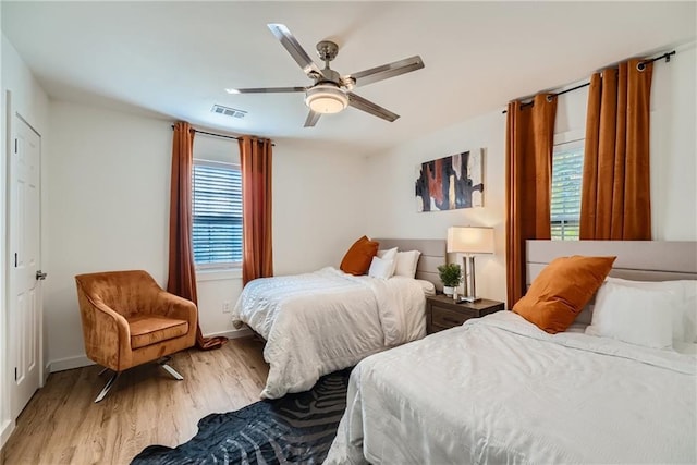 bedroom featuring multiple windows, light hardwood / wood-style flooring, and ceiling fan