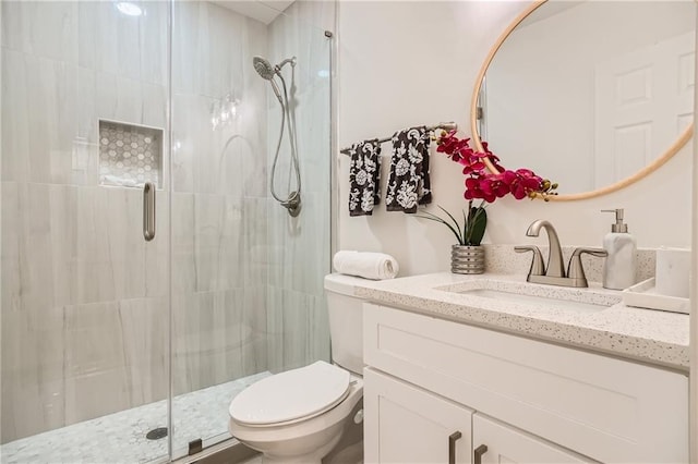 bathroom featuring toilet, an enclosed shower, and vanity