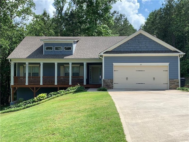 craftsman inspired home with a garage and a front lawn