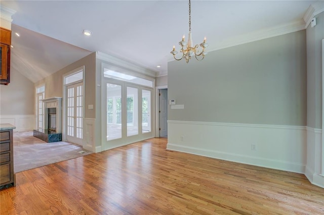 13935 Brown Bridge Rd, Covington, GA 30016 - unfurnished dining area with a chandelier, a high end fireplace, light wood-style floors, a wainscoted wall, and crown molding