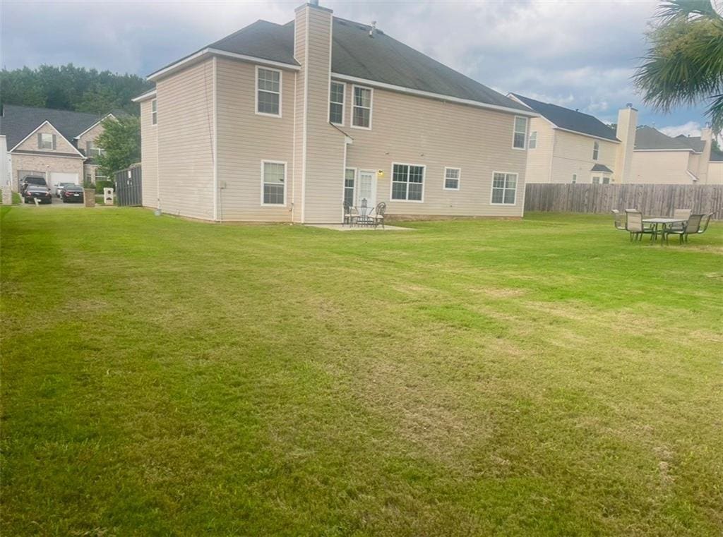 back of house with a lawn