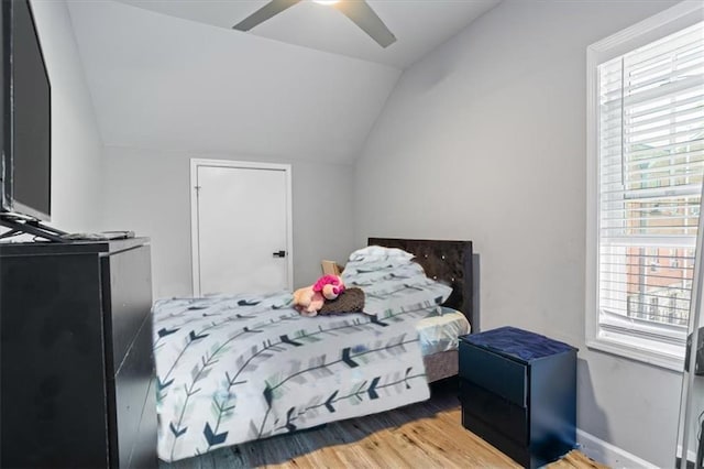 bedroom with ceiling fan, lofted ceiling, and wood finished floors