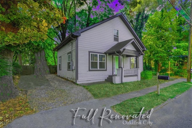 view of front of property featuring covered porch and fence