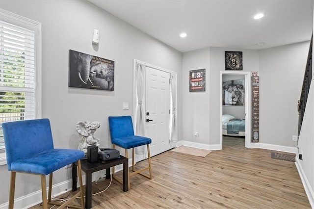 living area with recessed lighting, light wood-style floors, and baseboards