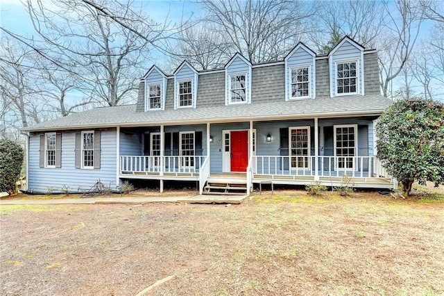 new england style home featuring a porch and a front lawn