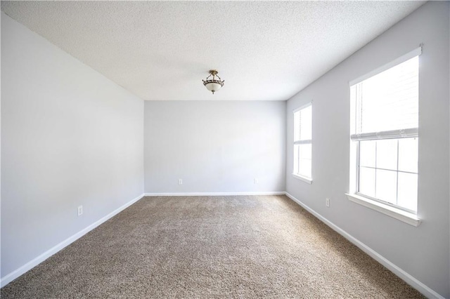 unfurnished room with a textured ceiling and carpet flooring