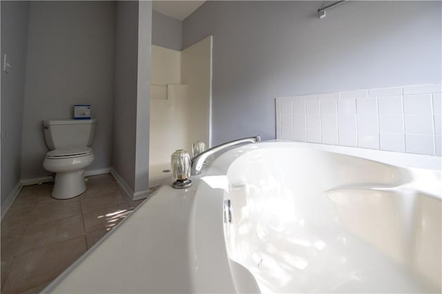 bathroom with toilet, a washtub, and tile patterned floors