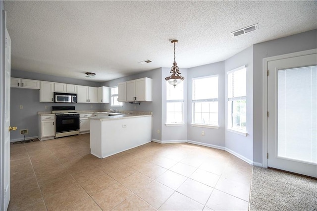 kitchen with white cabinets, plenty of natural light, decorative light fixtures, and white range oven