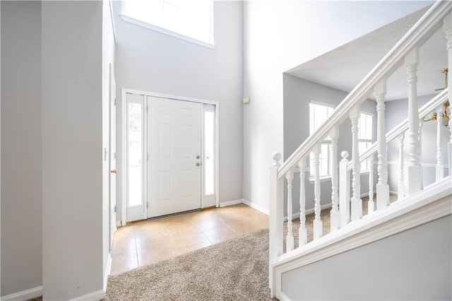 tiled entrance foyer with a towering ceiling