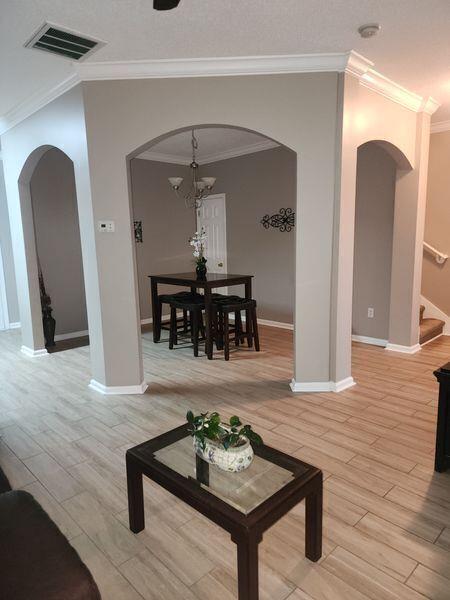 5449 Festival Ave, Fairburn, GA 30213 - living room featuring ornamental molding, arched walkways, stairway, and light wood-style flooring