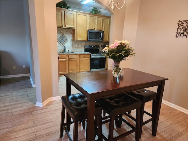5449 Festival Ave, Fairburn, GA 30213 - dining room featuring baseboards, light wood finished floors, and arched walkways