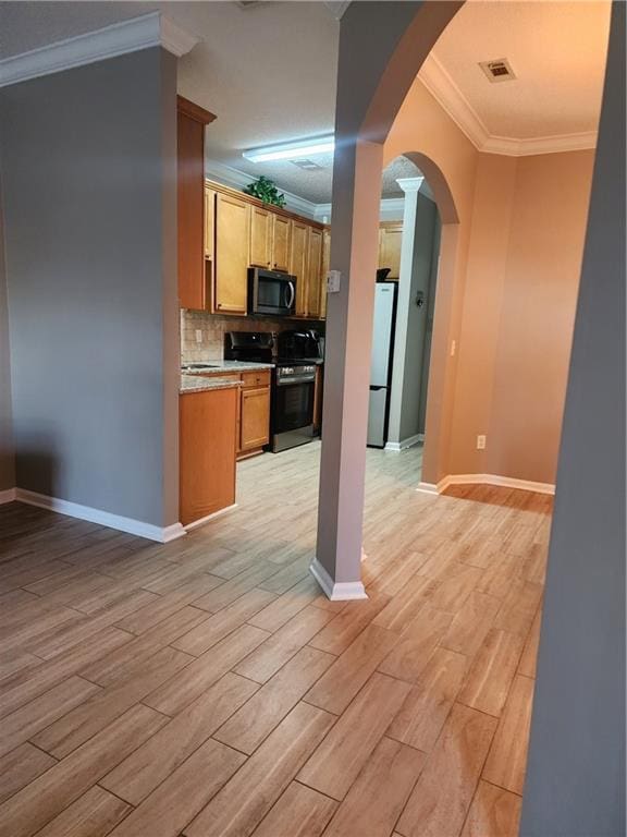 5449 Festival Ave, Fairburn, GA 30213 - kitchen with appliances with stainless steel finishes, arched walkways, ornamental molding, light wood-style flooring, and light countertops