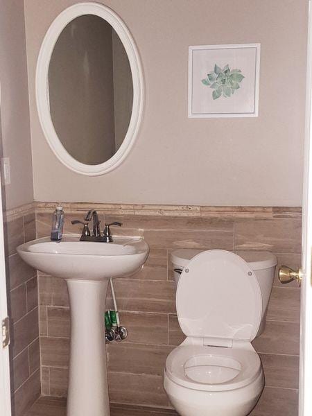 5449 Festival Ave, Fairburn, GA 30213 - half bathroom with tile walls, toilet, and wainscoting