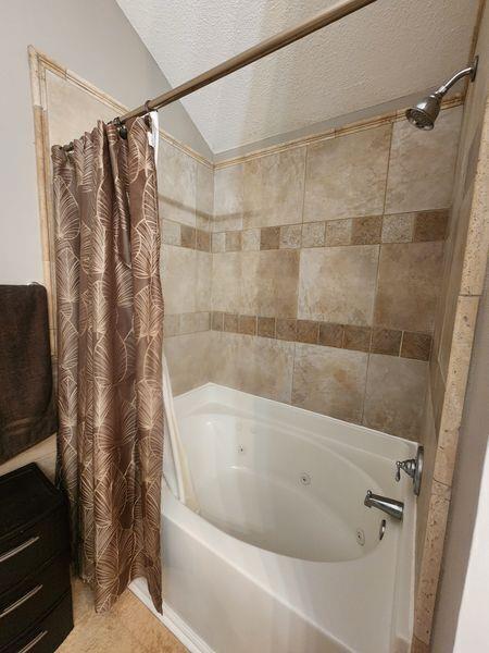 5449 Festival Ave, Fairburn, GA 30213 - bathroom featuring a combined bath / shower with jetted tub and a textured ceiling