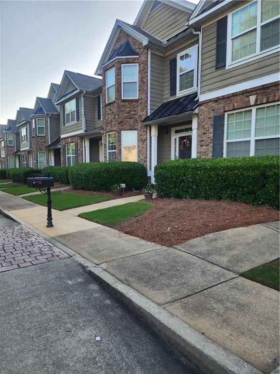 5449 Festival Ave, Fairburn, GA 30213 - view of property with a residential view, brick siding, a standing seam roof, and metal roof
