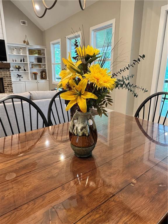 112 Three Oaks Dr SE, Calhoun, GA 30701 - dining area featuring vaulted ceiling and a brick fireplace