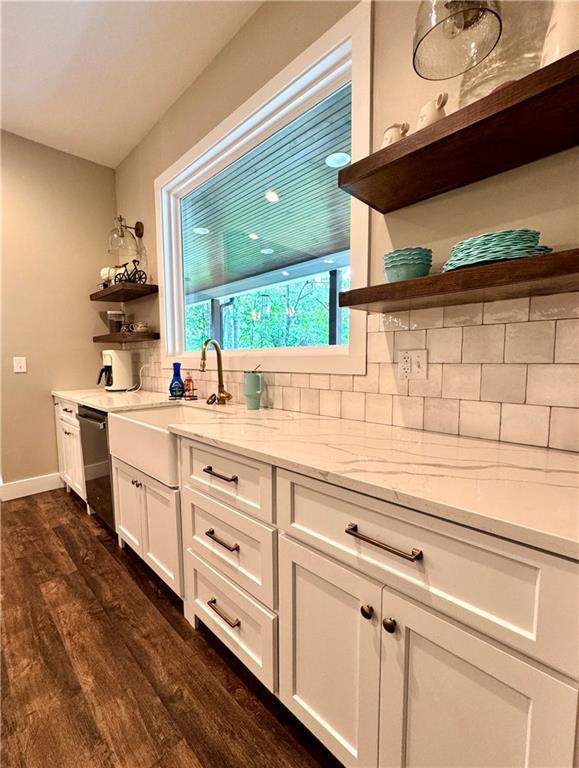 112 Three Oaks Dr SE, Calhoun, GA 30701 - kitchen with open shelves, stainless steel dishwasher, dark wood-type flooring, tasteful backsplash, and white cabinetry
