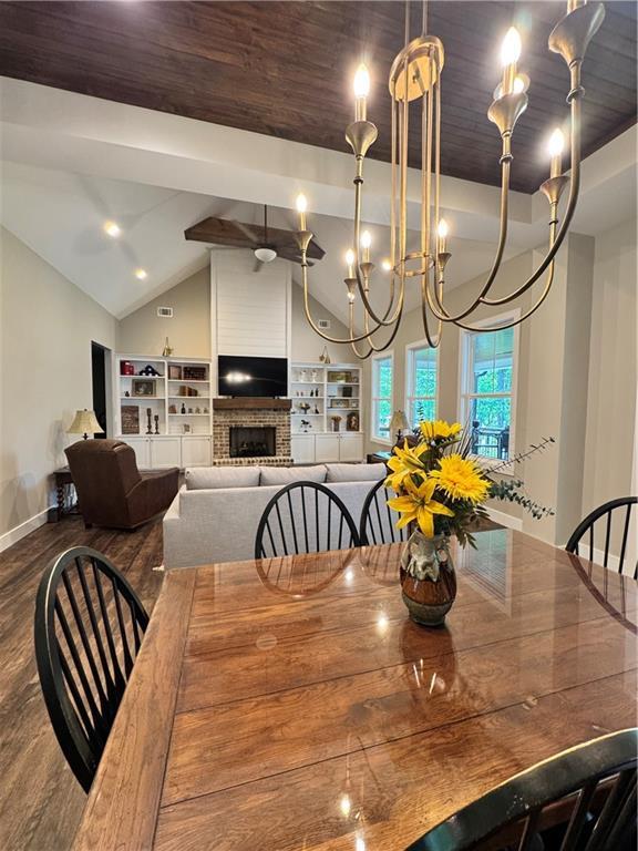 112 Three Oaks Dr SE, Calhoun, GA 30701 - dining area with wood finished floors, a fireplace, vaulted ceiling, and a chandelier