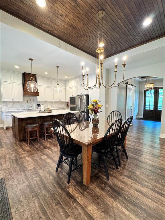 112 Three Oaks Dr SE, Calhoun, GA 30701 - dining room featuring dark wood-style flooring, wood ceiling, recessed lighting, arched walkways, and a barn door