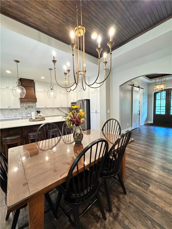 112 Three Oaks Dr SE, Calhoun, GA 30701 - dining room with a barn door, dark wood-style flooring, wooden ceiling, and arched walkways
